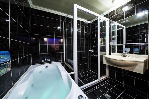 A modern bathroom with a bathtub, a shower enclosure, and a sink. - Wen Sha Bao (Tainan)