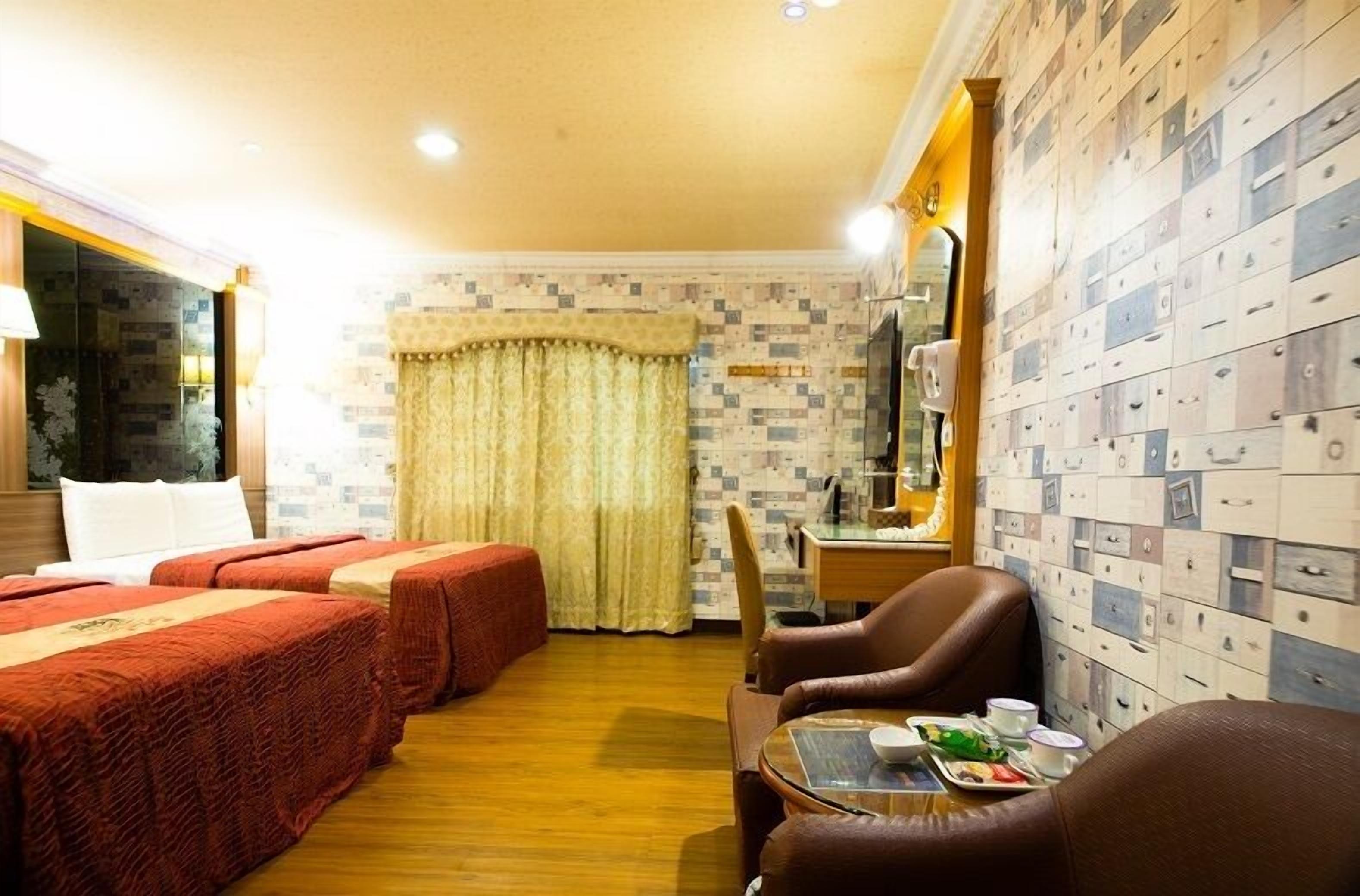 Une chambre d’hôtel avec deux lits, une table à manger où le petit-déjeuner est servi, et un mur entier composé de tiroirs de rangement.