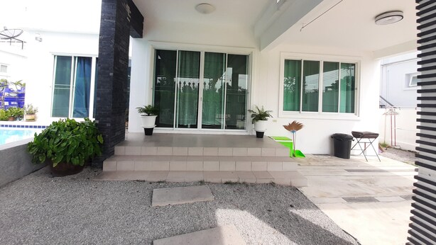 A modern house with a covered patio, a swimming pool, and potted plants. - Baan Pimsamai Pool Villa Hua Hin (Hua Hin)
