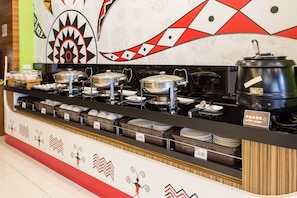 Un mostrador de buffet con diversos platos y recipientes.