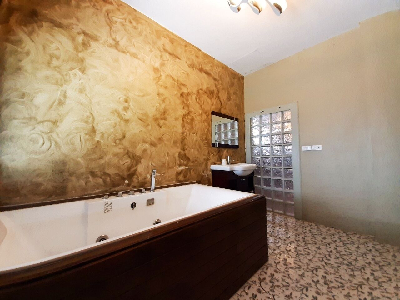 A bathroom with a large bathtub, a sink, and a mirror.
