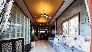 A spacious living area with a sofa, a glass partition, and a chandelier. - Baan Rainy Pool Villa Hua Hin (Hua Hin)