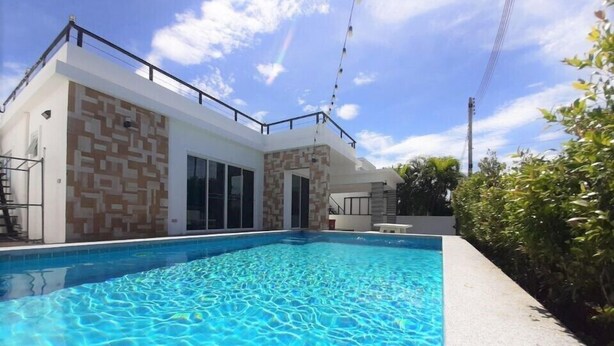 A modern house with a swimming pool, large windows, and a clear sky. - Baan Rolita Pool Villa Hua Hin (Hua Hin)