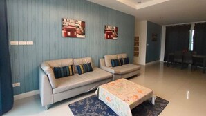 A modern living room with two sofas, a coffee table, and artwork on the walls. - Baan Rolita Pool Villa Hua Hin (Hua Hin)