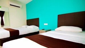A hotel room with two beds, each with a brown headboard and white bedding. There is a window with curtains, an air conditioning unit, and a small bedside table with a lamp. - Sg Pelek Hotel (Sungai Pelek)