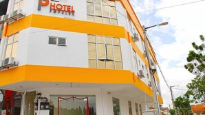 A hotel with a white and orange facade, large windows, and a visible entrance with a red ribbon. - Sg Pelek Hotel (Sungai Pelek)