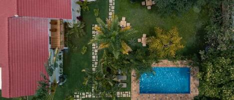 Ein Wohnhaus mit Swimmingpool, Außenbereich und einem Gebäude mit rotem Dach.