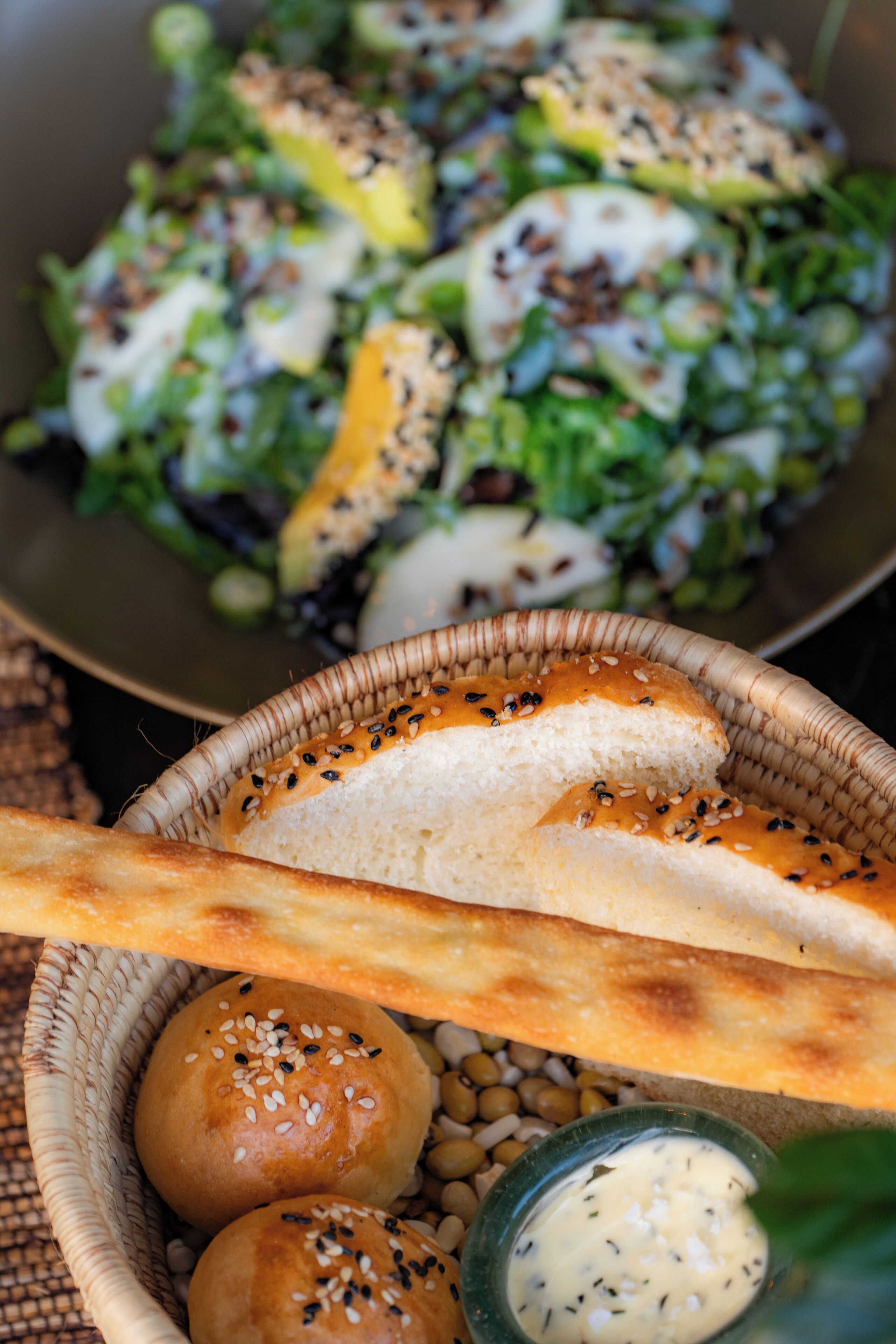 Un panier de petits pains et un saladier de salade.
