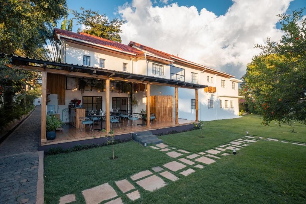 A two-story house with a covered patio, a small garden, and a stone pathway.