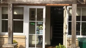 A wooden building with a gabled roof and a set of double doors leading into a staircase. - The Coach House Inn (Oakham)