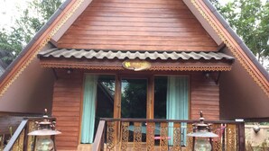 A wooden house with a balcony, two lantern-style lights, and a sign that reads "mango". - Himawari Restaurant & Cottage (Khon Kaen)