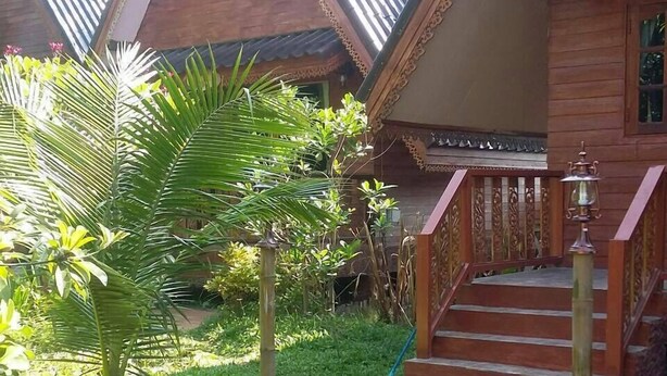 A traditional wooden house with a staircase leading to a porch. - Himawari Restaurant & Cottage (Khon Kaen)