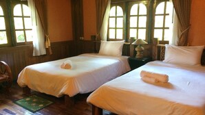 A room with two single beds, wooden floors, and large windows with curtains. - Himawari Restaurant & Cottage (Khon Kaen)