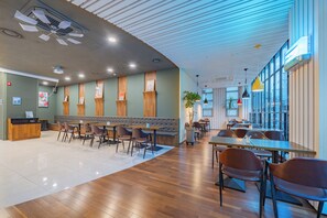 A modern restaurant with wooden flooring, a bar area, and a seating arrangement with tables and chairs. - Hotel STAY:ON (Geoje)