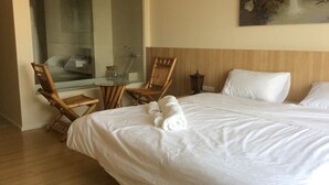 A hotel room with a large bed, two chairs, a small table, and a painting on the wall. - Himawari at Condo (Khon Kaen)