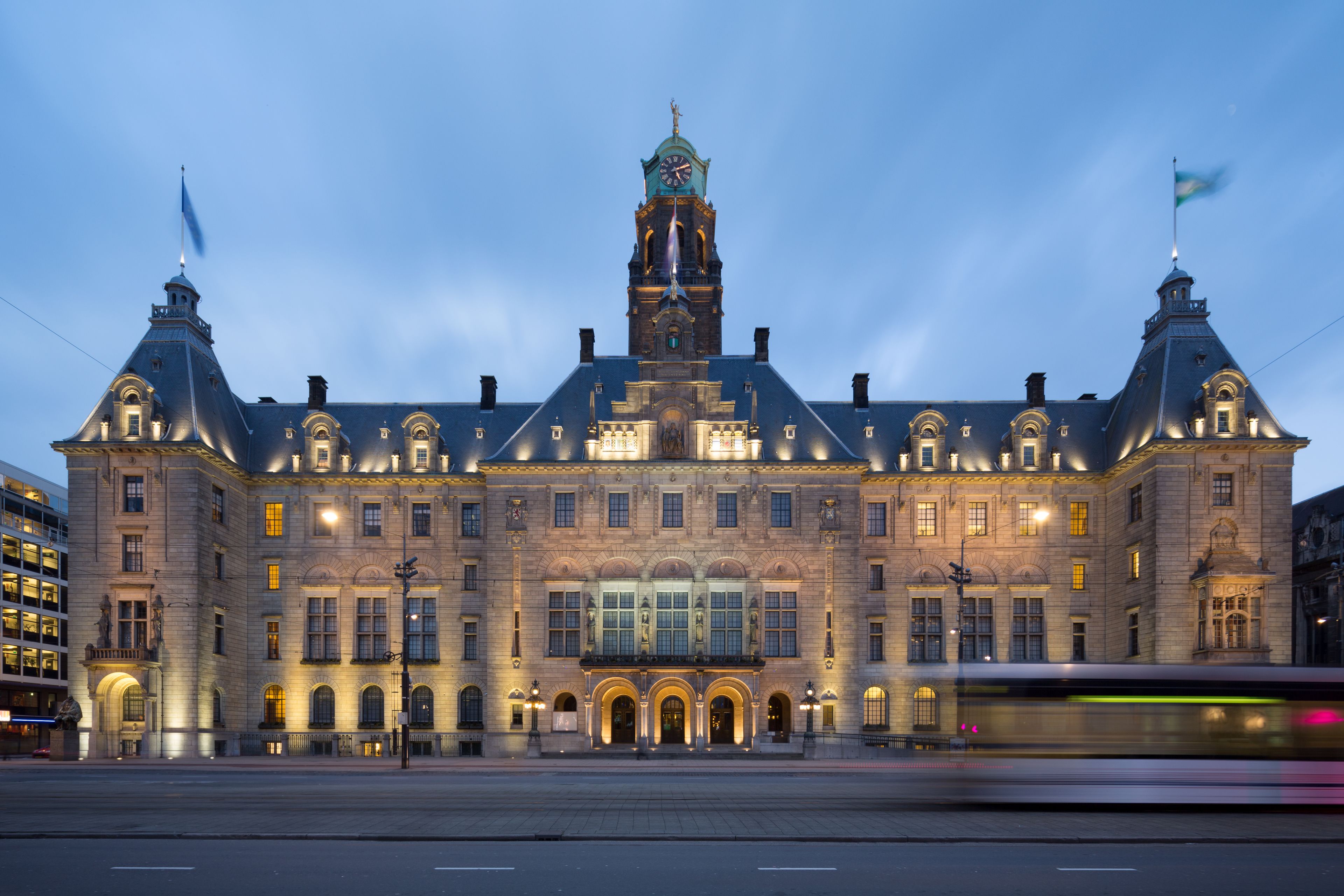 A large, historic building with a prominent clock tower, arched windows, and a central entrance.