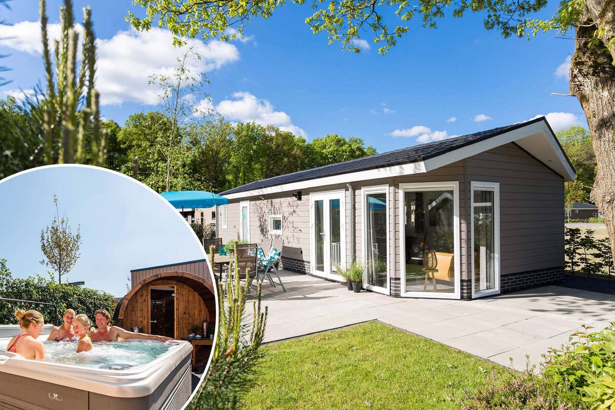 Ein modernes Haus mit Whirlpool, Terrasse und einem großen Baum.
