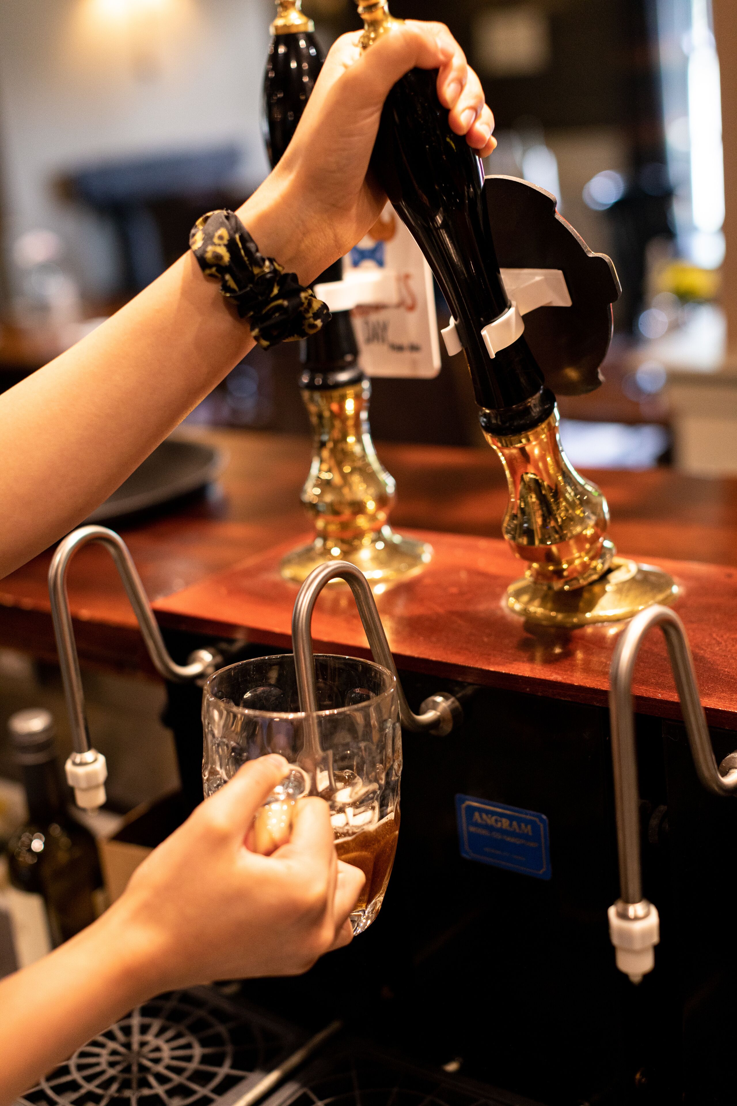 A person pouring beer from a tap into a glass.