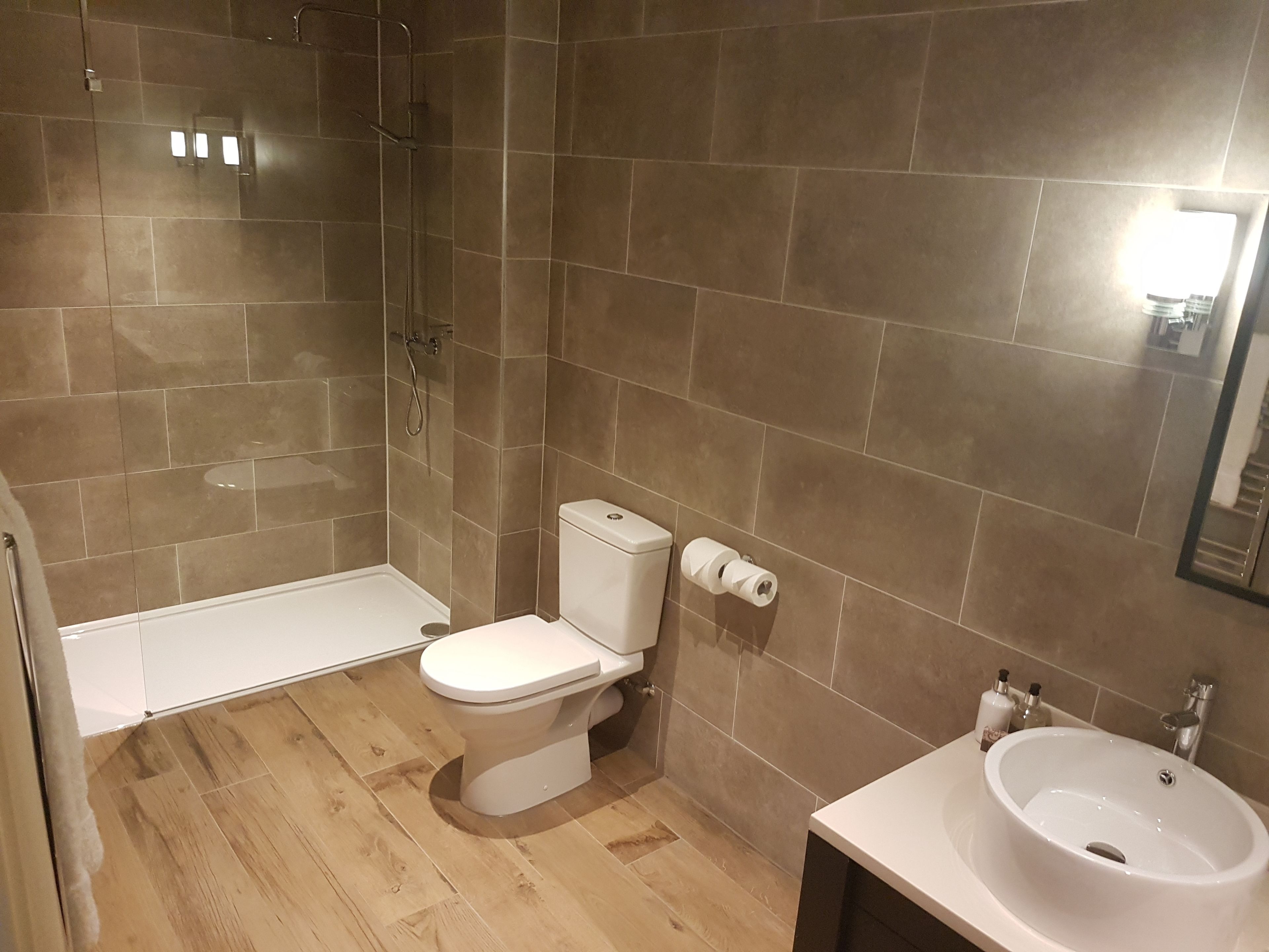 A bathroom with a shower, toilet, and sink.