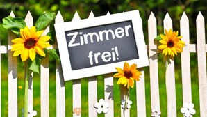 A sign with the text "Zimmer frei!" on a white fence with sunflowers. - Zimmervermietung Wesermarsch (Berne)