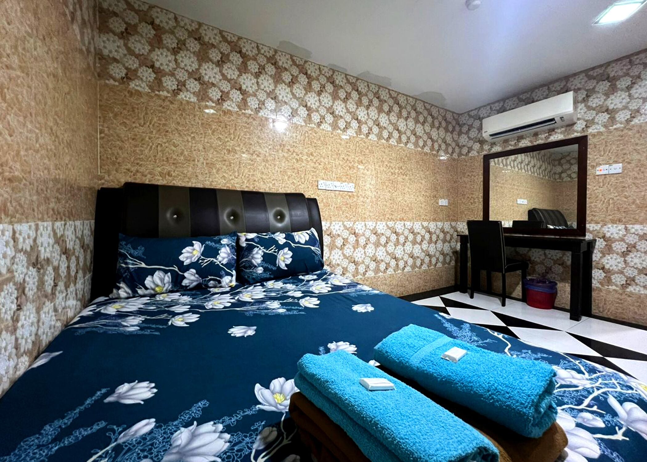 Ein Schlafzimmer mit einem Bett, einem Schreibtisch und einer Klimaanlage.