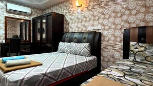 Habitación de hotel con dos camas, un armario, un espejo y un aire acondicionado.