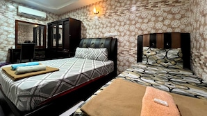 Habitación de hotel con dos camas, un escritorio y un espejo.