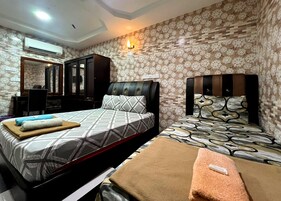 A hotel room with two beds, a desk, and a mirror.