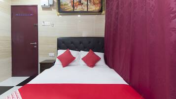 Relax in a spacious room with a large bed, a framed painting of horses, and a stylish headboard.