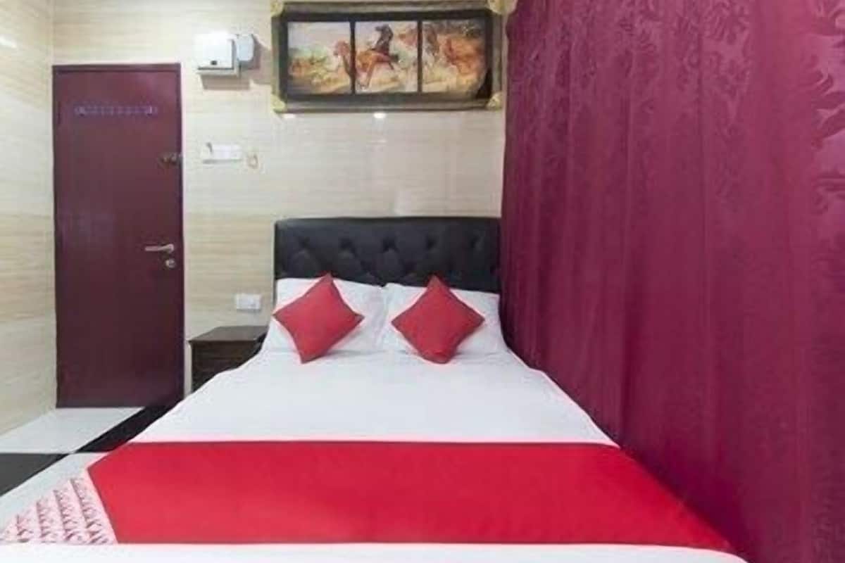 Une chambre d’hôtel avec un lit, une porte et un tableau au mur.