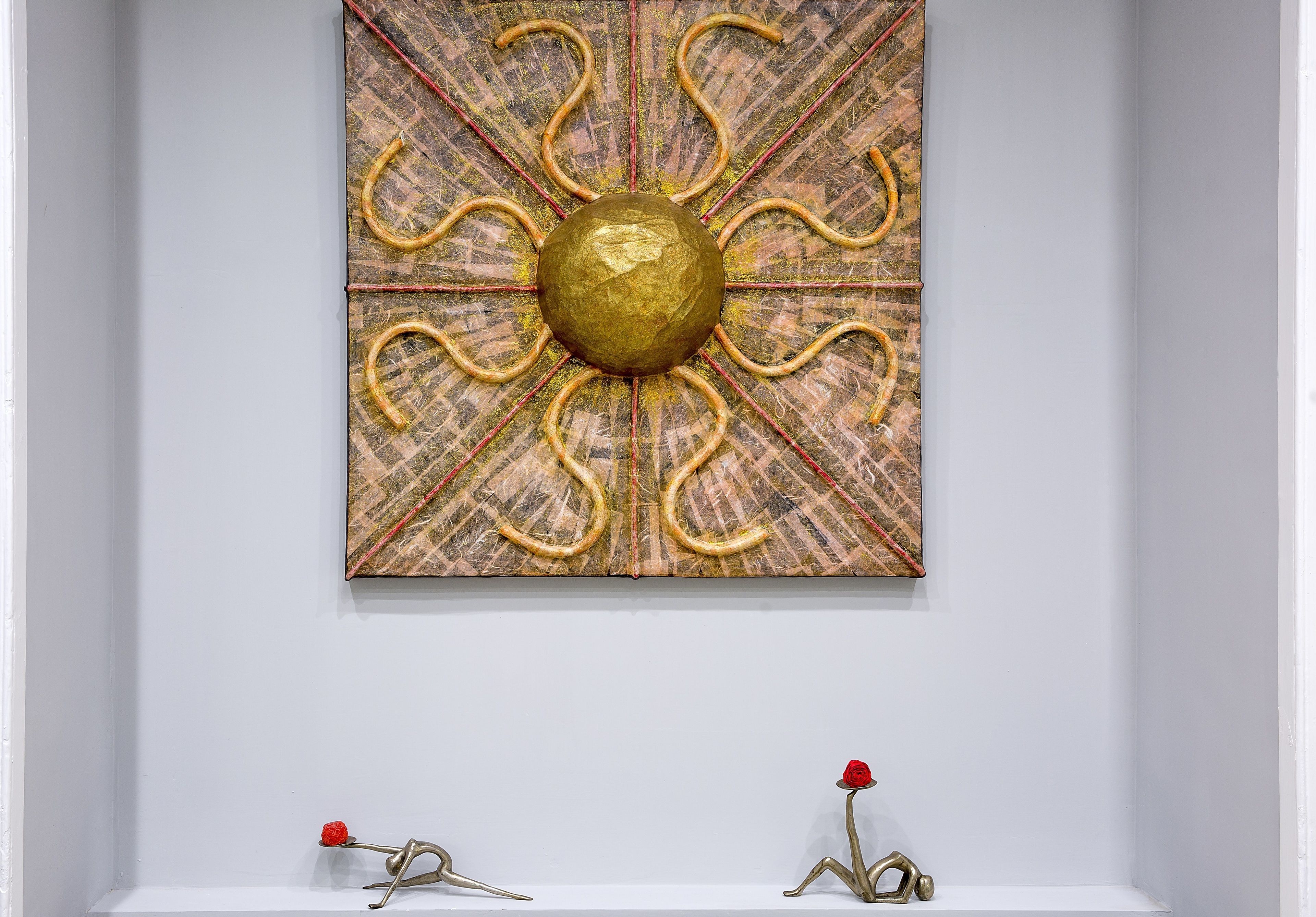 Wandkunst mit einem goldenen Mittelpunkt und strahlenförmigen Linien.