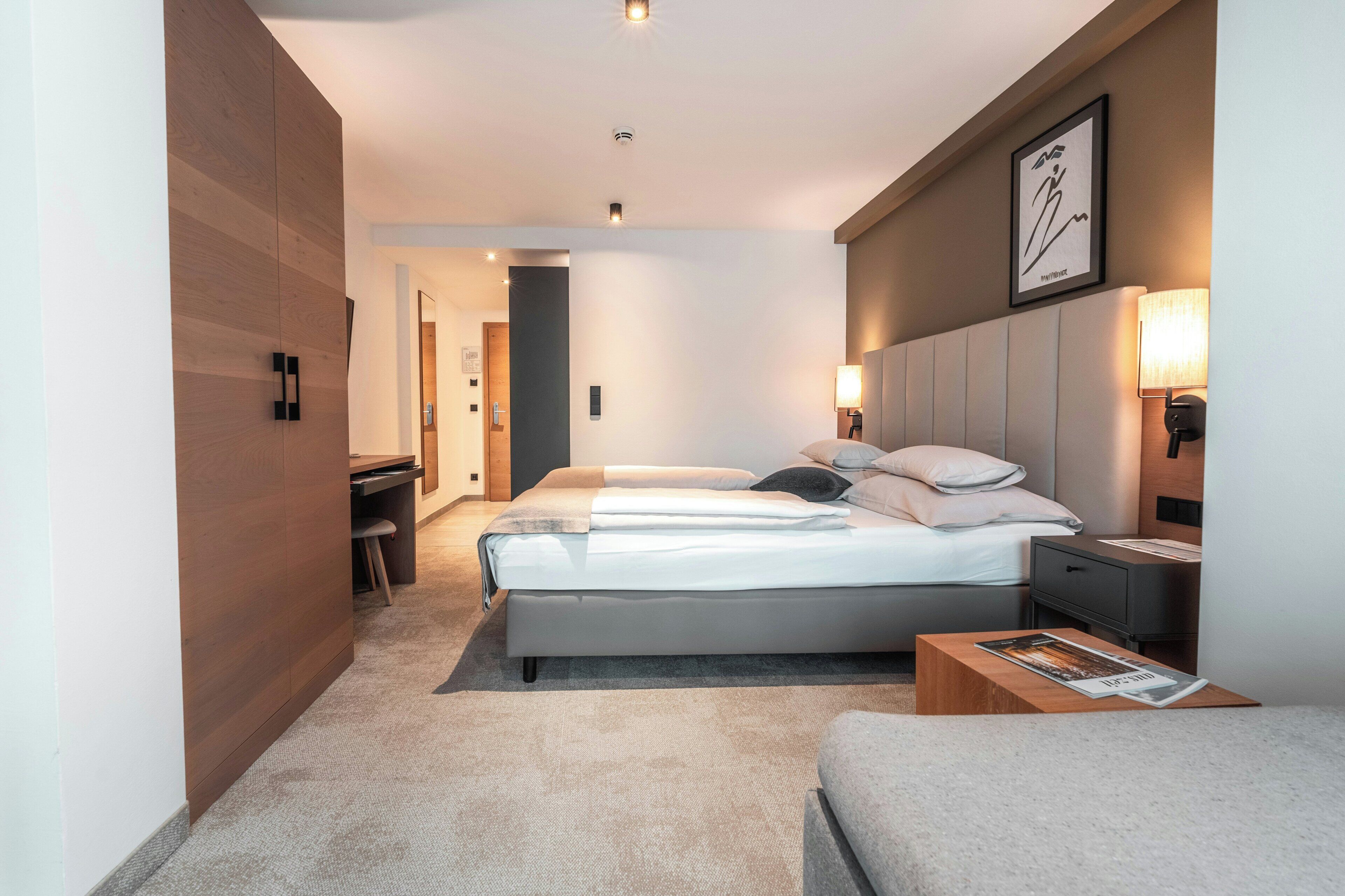 Une chambre d’hôtel moderne dotée d’un grand lit, d’un bureau et d’un coin salon.