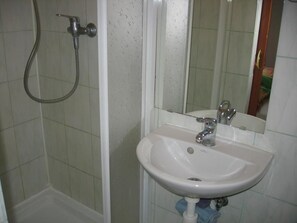 A bathroom with a shower, sink, and mirror. - Penzión Závada (Nova Lesna)
