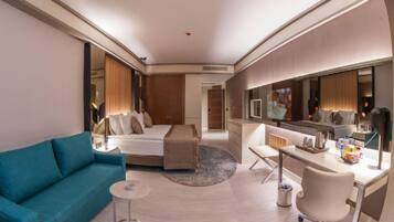 Una habitación de hotel con sofá, cama, escritorio, silla y espejo.