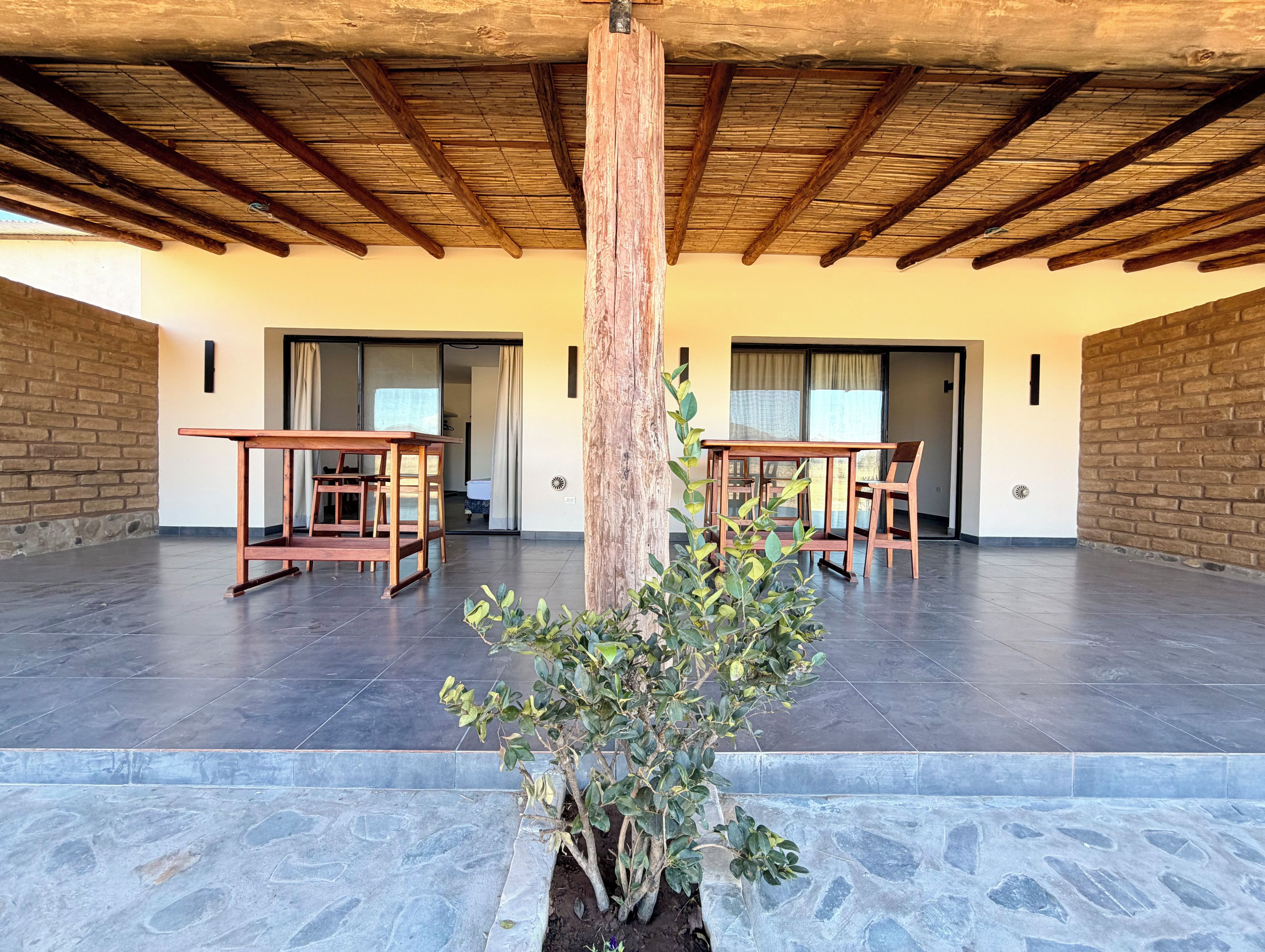 A spacious room with a tiled floor, wooden furniture, and a central column.