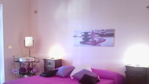 A bedroom with a bed, pillows, a nightstand, a lamp, and a picture on the wall. - B&B Rosa Dei Venti (Orvieto)