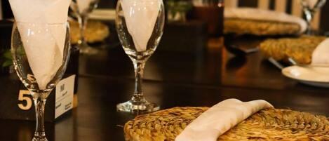 A table set for dining with white napkins folded into a decorative shape, a woven basket, and a number card indicating table 5.