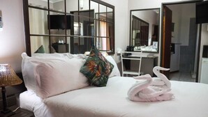 A hotel room with a neatly made bed, a desk, and a large mirror. - The Ultimate Lodge (Louis Trichardt)