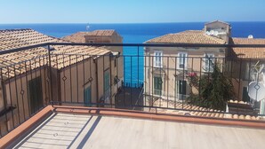 A balcony with a view of the sea and adjacent buildings. - B&B THE TOWER Tropea (Tropea)