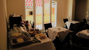 A breakfast buffet setup with various food items and a view of a building through a glass door. - B&B THE TOWER Tropea (Tropea)