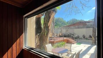 Un interior de madera con un amplio ventanal que da a un patio al aire libre.