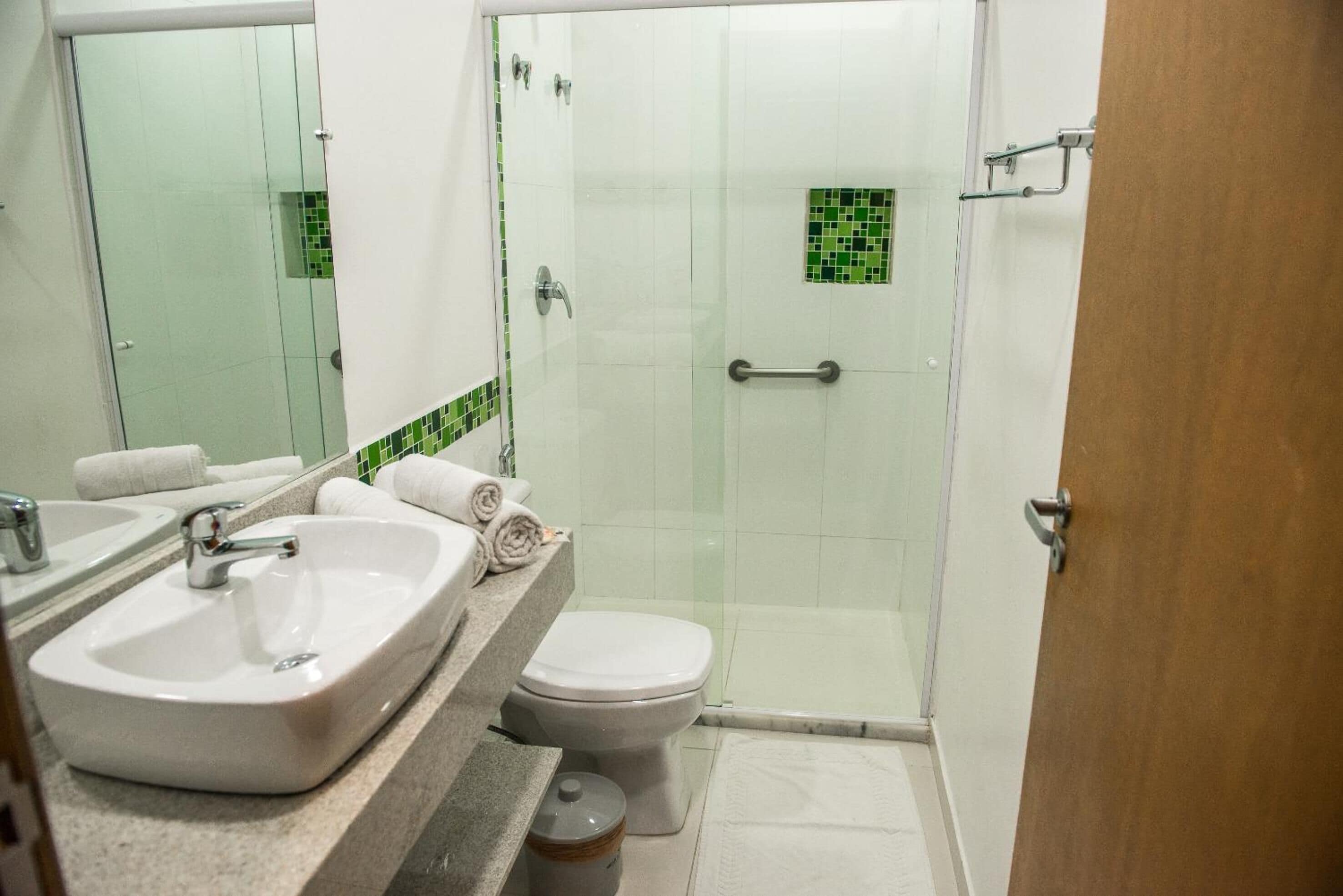 Un baño con lavamanos grande, inodoro y cabina de ducha de vidrio.