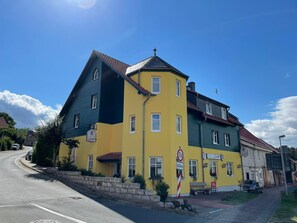 Un edificio amarillo con un letrero que dice 'Zander' y un letrero que indica un límite de peso de 7,5 toneladas.