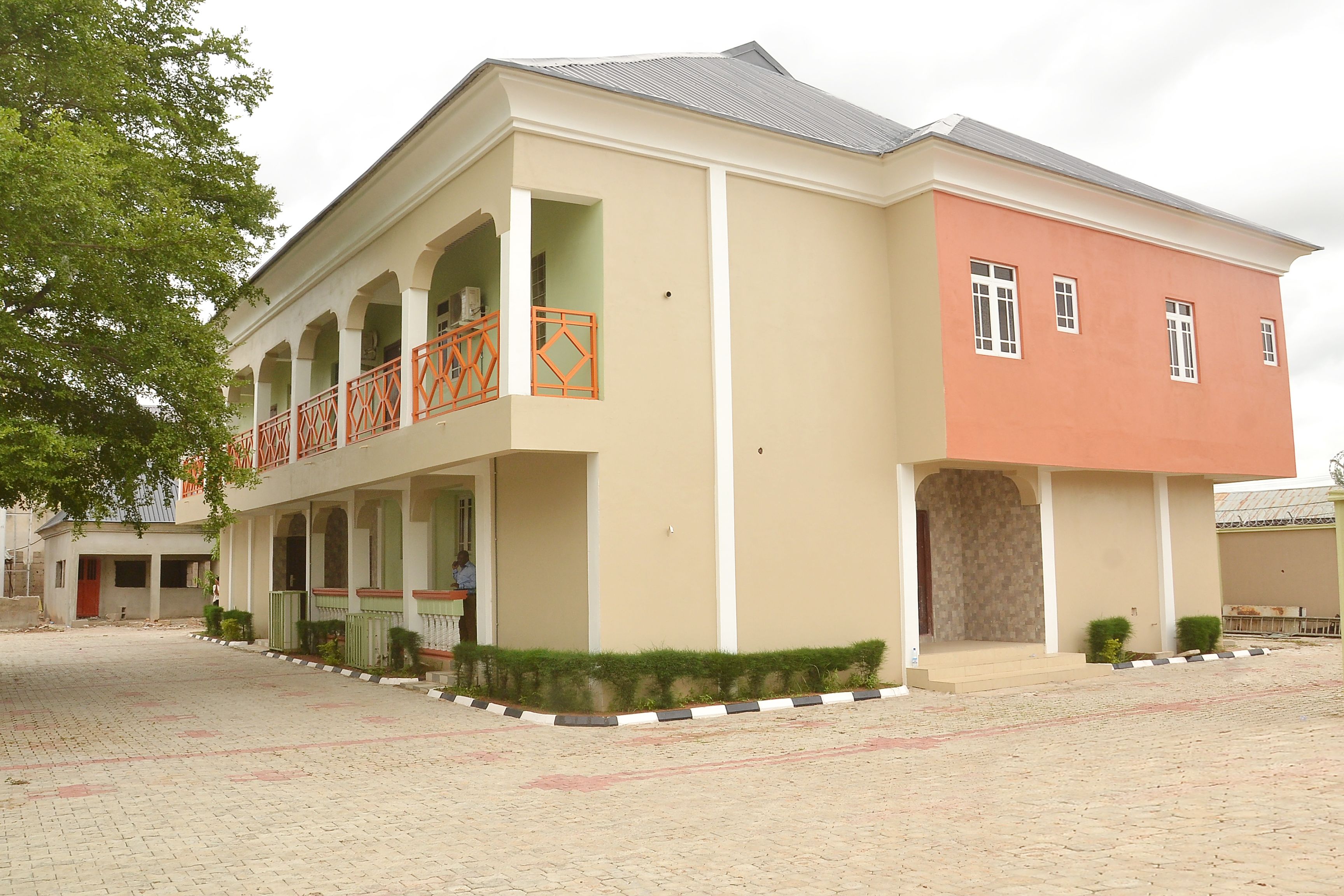 A two-story building with a balcony and a covered walkway.