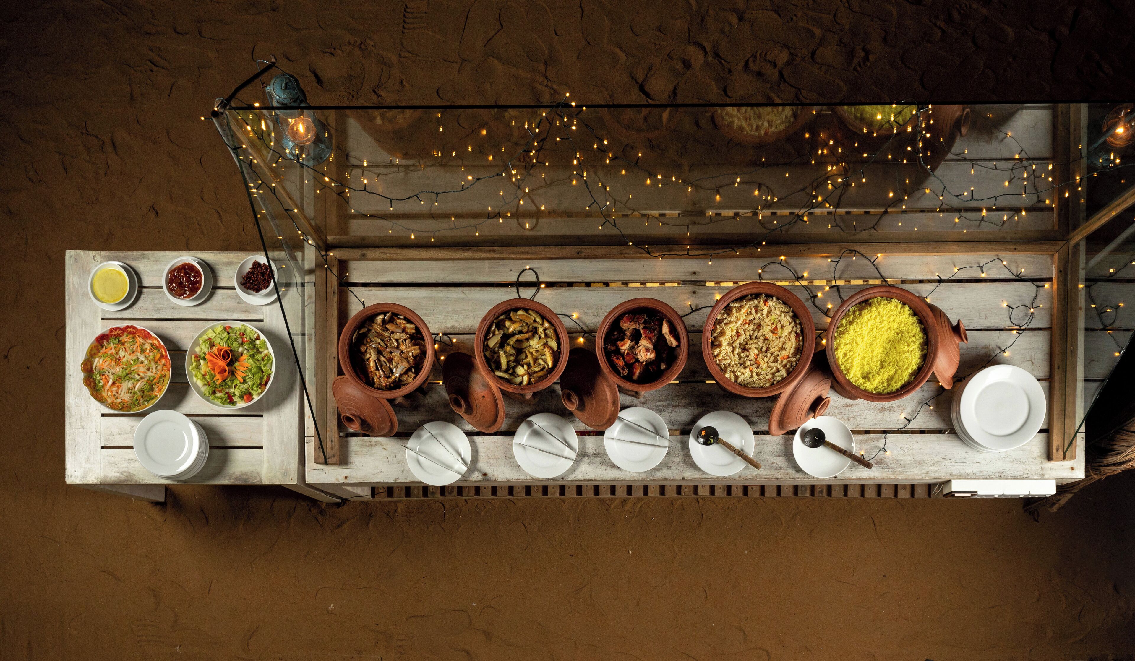 A top-down view of a buffet table with various dishes and serving utensils.