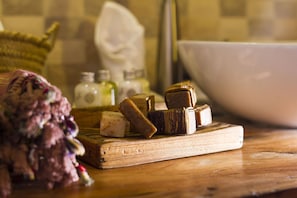 A wooden cutting board with various blocks of cheese and a bouquet of flowers on a kitchen counter. - Ujamaa Beach Resort Zanzibar (Makunduchi)