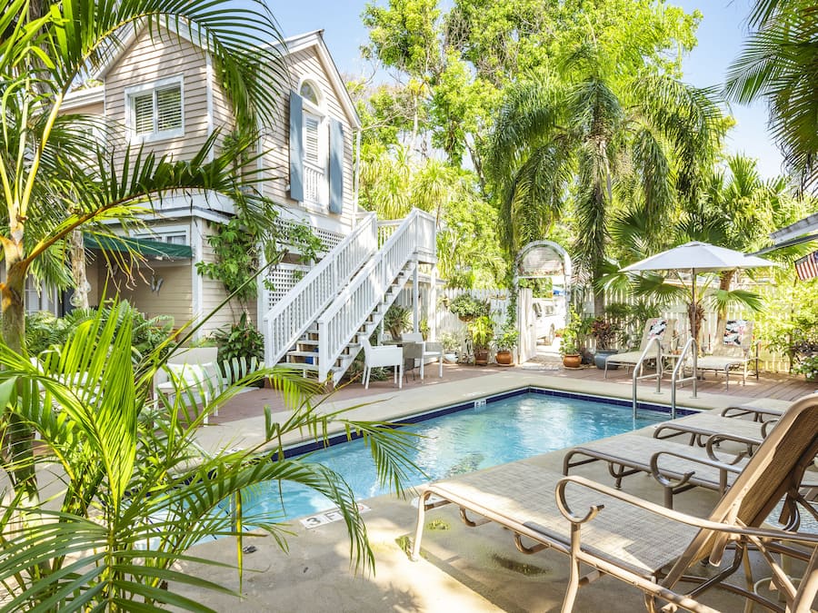 Una piscina al aire libre, sillones reclinables de piscina