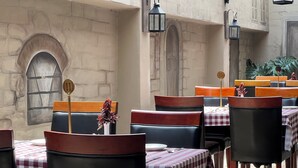 A restaurant with checkered tablecloths, leather chairs, and numbered signs indicating table positions. - Lotus by Serendib (Blantyre)