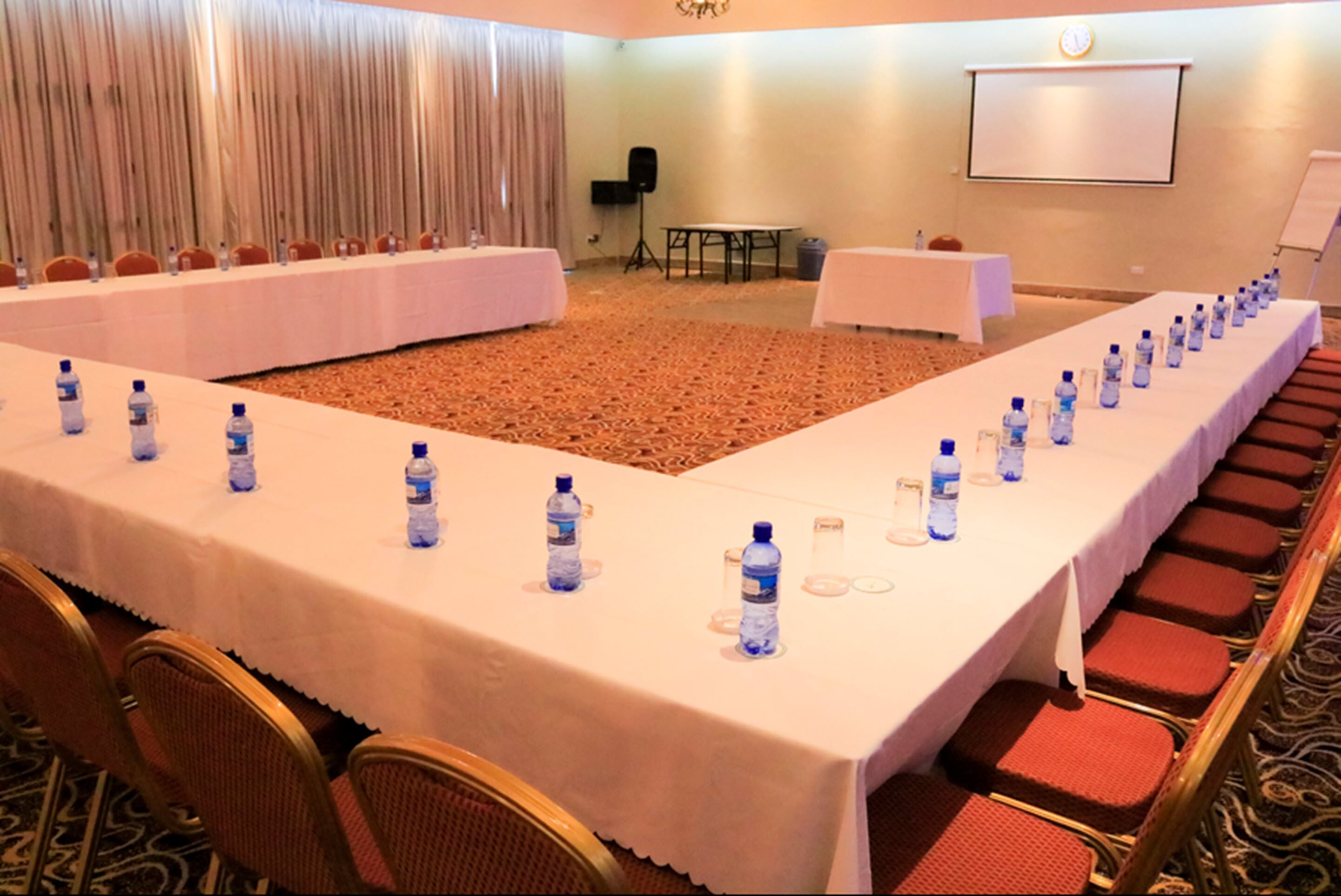 A conference room with a long table, chairs, and water bottles.