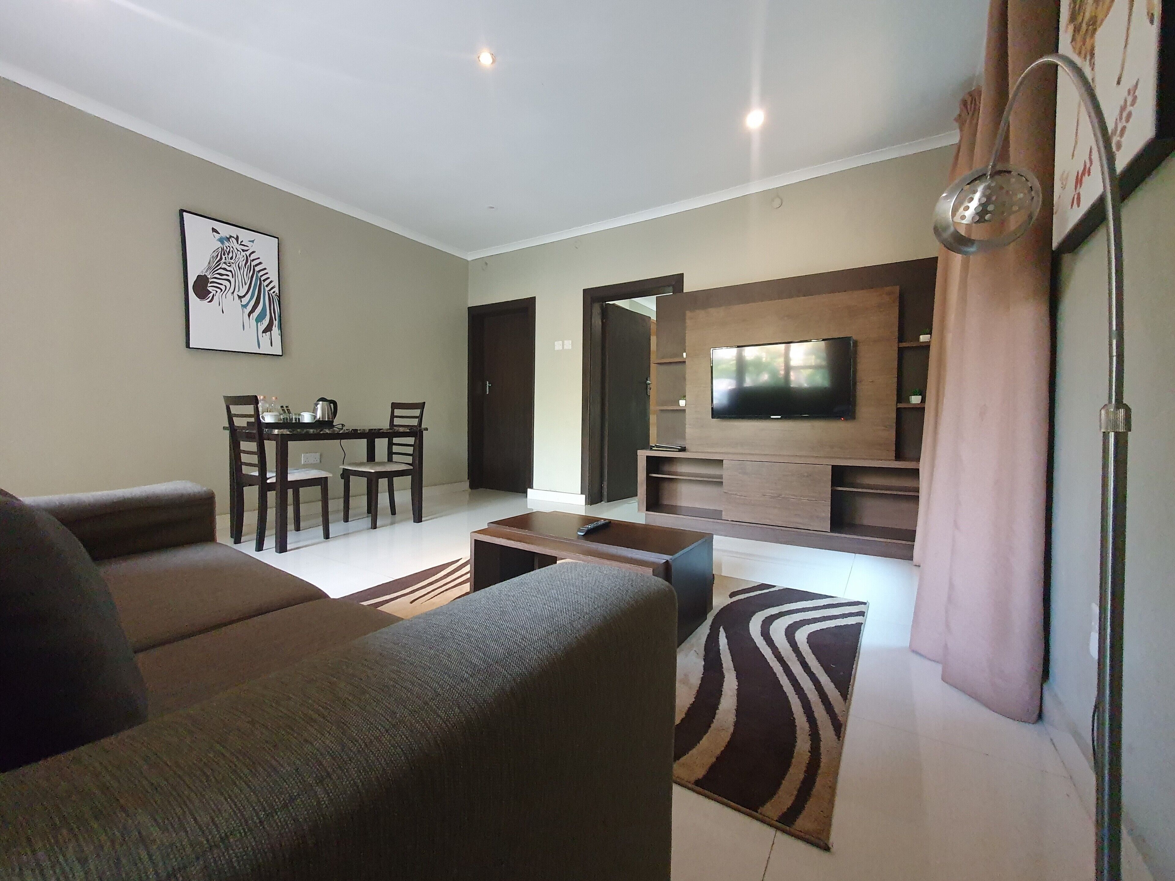 Una sala de estar con sofá, mesa de centro, televisor y comedor con sillas y una mesa.